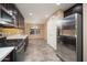 Bright kitchen featuring stainless steel appliances, dark cabinets, and tile floors at 18344 W Getty Dr, Goodyear, AZ 85338