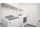 Laundry room featuring two appliances, white walls, shelves, and a door at 18344 W Getty Dr, Goodyear, AZ 85338