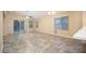 Open living room with tile flooring, ceiling fan, and sliding glass door for natural light at 18344 W Getty Dr, Goodyear, AZ 85338