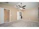 Bright primary bedroom featuring a ceiling fan, large windows, and an ensuite bathroom at 18344 W Getty Dr, Goodyear, AZ 85338