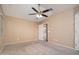 Bright primary bedroom featuring a ceiling fan, large windows, and an ensuite bathroom at 18344 W Getty Dr, Goodyear, AZ 85338