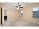 Bright primary bedroom featuring a ceiling fan, large windows, and an ensuite bathroom at 18344 W Getty Dr, Goodyear, AZ 85338