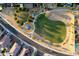 Aerial view of a well-maintained park with playground, green spaces, and walking paths at 18344 W Getty Dr, Goodyear, AZ 85338
