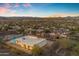 Expansive aerial view showcasing the neighborhood with city lights in the distance under a twilight sky at 1917 E Karen Dr, Phoenix, AZ 85022