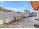 Open backyard area with tile patio, partial landscaping, and a tall wall for privacy at 1917 E Karen Dr, Phoenix, AZ 85022