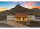 A desert home with a red tile roof, well-manicured steps, and desert landscaping nestled against a mountain at 1917 E Karen Dr, Phoenix, AZ 85022