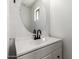 Bathroom featuring vanity with white countertop, black faucet, and large round mirror at 2112 S 160Th Dr, Goodyear, AZ 85338