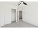 Bright bedroom showing a ceiling fan, closet with sliding doors, and doorway leading to the hallway at 2112 S 160Th Dr, Goodyear, AZ 85338