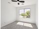 Bright bedroom showcasing a ceiling fan and a large window with a view of the neighborhood at 2112 S 160Th Dr, Goodyear, AZ 85338