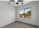 Carpeted bedroom featuring a ceiling fan and large window with views of the surrounding neighborhood at 2112 S 160Th Dr, Goodyear, AZ 85338