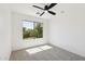 Bright bedroom featuring a ceiling fan and a large window with a view of mature trees at 2112 S 160Th Dr, Goodyear, AZ 85338