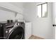 Functional laundry room features a newer washer and dryer and a window for natural light at 2112 S 160Th Dr, Goodyear, AZ 85338