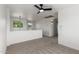 Bright loft space with neutral carpet, large windows, and modern ceiling fan at 2112 S 160Th Dr, Goodyear, AZ 85338