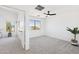 Bright open bedroom featuring neutral carpet, ceiling fan, and large windows with views of the exterior at 2112 S 160Th Dr, Goodyear, AZ 85338
