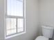 Well-lit bathroom featuring a toilet next to a window bringing in natural light at 2223 E Catalina Dr, Phoenix, AZ 85016