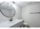 Modern bathroom with a round mirror, updated lighting, sleek vanity, and neutral color scheme at 2223 E Catalina Dr, Phoenix, AZ 85016