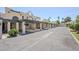 Condos feature covered parking, beige stucco, and well-maintained grounds under a clear blue sky at 2223 E Catalina Dr, Phoenix, AZ 85016