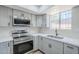 Updated kitchen features stainless appliances, gray cabinets, and quartz countertops at 2223 E Catalina Dr, Phoenix, AZ 85016