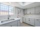 Gray cabinets, stainless steel sink and quartz countertops are featured in this bright modern kitchen at 2223 E Catalina Dr, Phoenix, AZ 85016