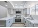 Updated kitchen featuring stainless steel appliances, modern gray cabinets, and quartz countertops at 2223 E Catalina Dr, Phoenix, AZ 85016