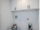 Functional laundry room with white cabinets and utility connections at 2223 E Catalina Dr, Phoenix, AZ 85016