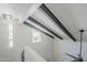 Modern staircase with black beams and a contemporary light fixture at 2223 E Catalina Dr, Phoenix, AZ 85016