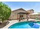 Backyard pool area with a covered patio, green foliage and clear blue skies at 22670 N Kennedy Dr, Maricopa, AZ 85138