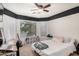 A bright bedroom with a large window, a ceiling fan and a writing desk at 22670 N Kennedy Dr, Maricopa, AZ 85138