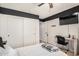 A bright bedroom with a ceiling fan, a writing desk, and closet space at 22670 N Kennedy Dr, Maricopa, AZ 85138