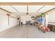 Spacious garage with ample storage, shelving, workbench, and two-wheeled motorbike at 22670 N Kennedy Dr, Maricopa, AZ 85138