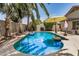 Backyard pool surrounded by lush greenery and palm trees, perfect for relaxation at 22670 N Kennedy Dr, Maricopa, AZ 85138