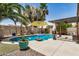 Backyard pool with desert landscaping, an umbrella, and a pergola, perfect for outdoor entertaining at 22670 N Kennedy Dr, Maricopa, AZ 85138
