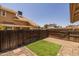 The backyard features artificial grass and a brick patio surrounded by a wooden fence at 2455 E Broadway Rd # 122, Mesa, AZ 85204