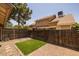 The backyard features artificial grass and a brick patio surrounded by a wooden fence at 2455 E Broadway Rd # 122, Mesa, AZ 85204