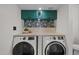 Efficient laundry room with stacked washer/dryer and stylish floral wallpaper at 2455 E Broadway Rd # 122, Mesa, AZ 85204