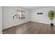 Bright living room featuring wood-look floors, a large window and a bracket for a wall mounted television at 2455 E Broadway Rd # 122, Mesa, AZ 85204