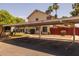Assigned covered parking adjacent to unit with desert landscaping and red fence at 2455 E Broadway Rd # 122, Mesa, AZ 85204