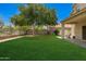 A lush green lawn bordered by trees, shrubs, and a block fence at 25210 N 40Th Ave, Phoenix, AZ 85083