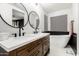 Well-lit double vanity bathroom featuring a wooden cabinet, matte black hardware, and attractive wall mirror at 25210 N 40Th Ave, Phoenix, AZ 85083