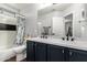 Stylish bathroom boasts double sinks with black fixtures, a shower with decorative curtain, and wood-look flooring at 25210 N 40Th Ave, Phoenix, AZ 85083