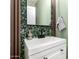 Stylish powder room featuring a white vanity, matte black fixtures, and attractive floral wallpaper accents at 25210 N 40Th Ave, Phoenix, AZ 85083