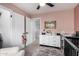 Cozy pink Bedroom with a dresser and changing table, adjacent to walk-in closet and hallway at 25210 N 40Th Ave, Phoenix, AZ 85083