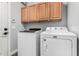 The laundry room features a side-by-side washer and dryer with overhead cabinets at 25210 N 40Th Ave, Phoenix, AZ 85083