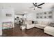 Open concept living room featuring a modern ceiling fan, wood floors, and connection to the kitchen at 25210 N 40Th Ave, Phoenix, AZ 85083