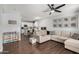 Open concept living room featuring a modern ceiling fan, wood floors, and connection to the kitchen at 25210 N 40Th Ave, Phoenix, AZ 85083