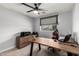 Functional home office featuring a large desk, comfortable gaming chair, and modern ceiling fan at 25210 N 40Th Ave, Phoenix, AZ 85083