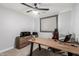 Functional home office featuring a large desk, comfortable gaming chair, and modern ceiling fan at 25210 N 40Th Ave, Phoenix, AZ 85083