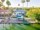 Stunning waterfront home featuring a private pool, dock, and lush landscaping with mature palm trees at 2552 S Playa --, Mesa, AZ 85202
