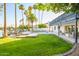 Lush backyard featuring a sparkling pool, manicured lawn, waterfront views, and a patio with seating at 2552 S Playa --, Mesa, AZ 85202