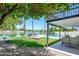 Tranquil backyard with a sparkling pool, lush green lawn, serene lake views, and an inviting covered patio at 2552 S Playa --, Mesa, AZ 85202